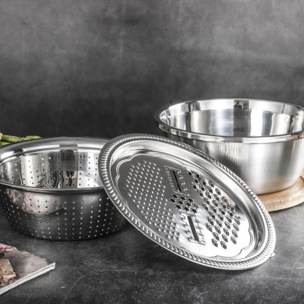 Stainless steel grater and bowl set on a dark surface with a blurred background