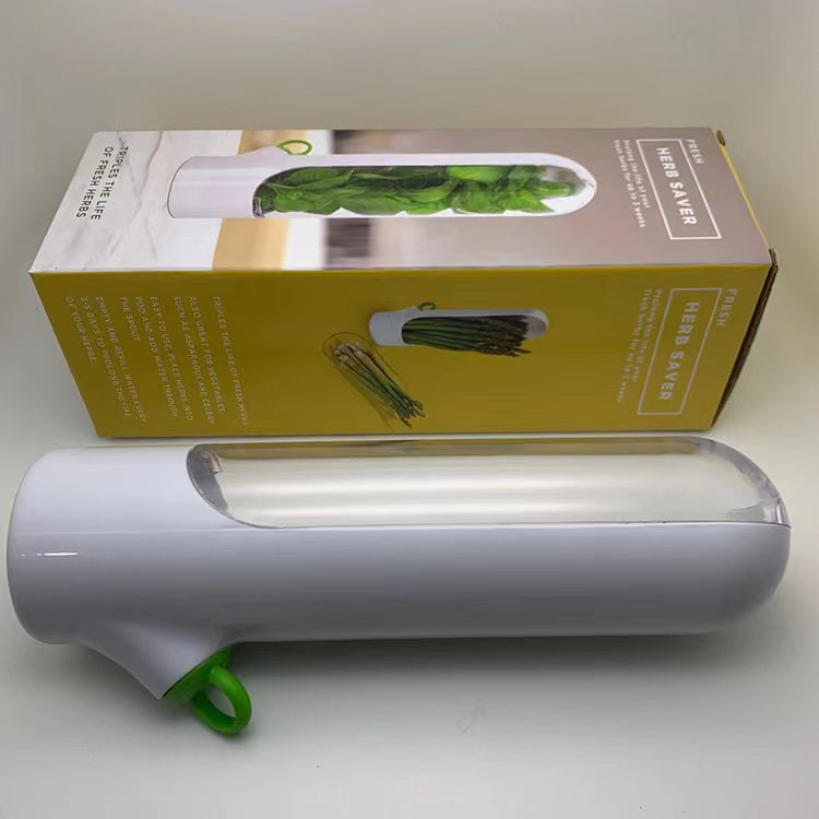 White herb saver with green handle on a white background, accompanied by its packaging.