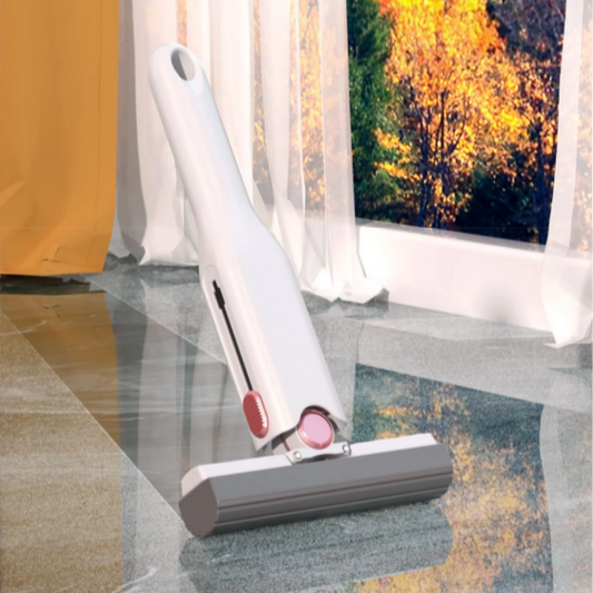 A white mini portable cleaning tool with red accents on a glass surface, with a blurred outdoor scene in the background.
